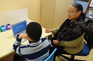 WBA teacher working with a young male student on reading skills