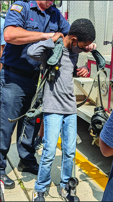 Dressing the part. Bloomfield Fire Department staff work with Westbridge Academy students in hands-on learning activities