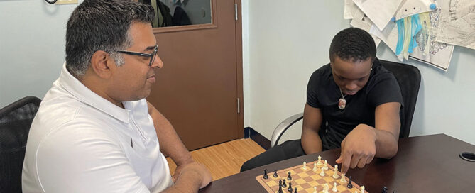 Principal Abraham mathews with student playing chess