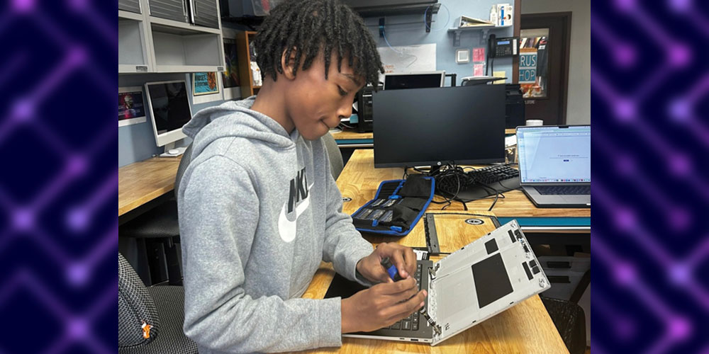 Westbridge student working on a piece of computer hardware